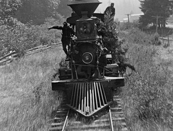 Movie still from “The General” (1926), directed by Buster Keaton – A black - and - white photo of a train on the tracks; Extreme Wide shot, High angle