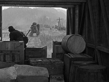 Movie still from “The General” (1926), directed by Buster Keaton – An old train is traveling down the tracks; Wide shot, High angle