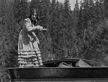Movie still from “The General” (1926), directed by Buster Keaton – An old photo of a woman standing on top of a boat; Wide shot, Low angle