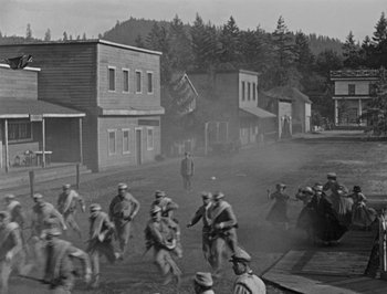 Movie still from “The General” (1926), directed by Buster Keaton – A black and white photo of a group of men on bicycles; Extreme Wide shot, High angle