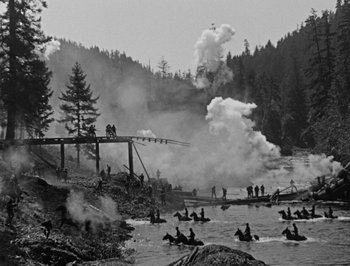 Movie still from “The General” (1926), directed by Buster Keaton – A black and white photo of people on horses in the water; Extreme Wide shot, High angle