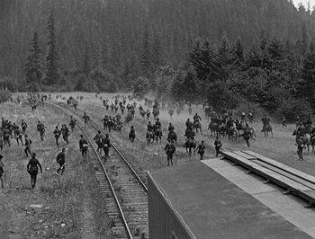 Movie still from “The General” (1926), directed by Buster Keaton – A black and white photo of a group of people riding horses; Extreme Wide shot, High angle