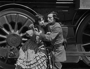 Movie still from “The General” (1926), directed by Buster Keaton – A man and a woman are standing next to each other; Medium shot, Low angle