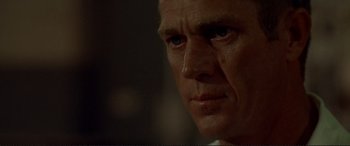 Movie still from “The Getaway” (1972), directed by Sam Peckinpah – A man's face in a dark room; Close Up shot, Over the shoulder angle