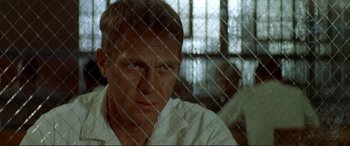 Movie still from “The Getaway” (1972), directed by Sam Peckinpah – A person behind a fence; Close Up shot, Over the shoulder angle