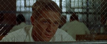 Movie still from “The Getaway” (1972), directed by Sam Peckinpah – A person behind a chain link fence; Close Up shot, Over the shoulder angle
