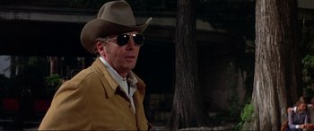Movie still from “The Getaway” (1972), directed by Sam Peckinpah – A man wearing a cowboy hat and a yellow jacket; Close Up shot, Over the shoulder angle