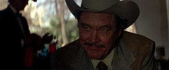 Movie still from “The Getaway” (1972), directed by Sam Peckinpah – A person wearing a cowboy hat; Close Up shot, Over the shoulder angle