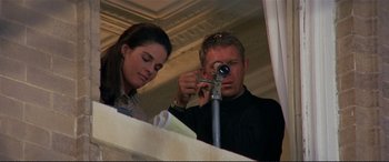 Movie still from “The Getaway” (1972), directed by Sam Peckinpah – A man and a woman looking through a telescope; Medium shot, Low angle