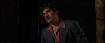 Movie still from “The Getaway” (1972), directed by Sam Peckinpah – A man with a mustache wearing a suit and tie; Close Up shot, Low angle