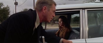 Movie still from “The Getaway” (1972), directed by Sam Peckinpah – A man and a woman sitting in the back of a car; Medium shot, Low angle