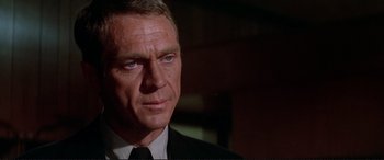 Movie still from “The Getaway” (1972), directed by Sam Peckinpah – A man in a suit and tie looking to his left; Close Up shot, Over the shoulder angle