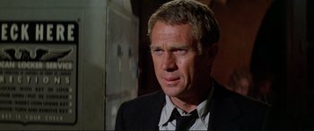 Movie still from “The Getaway” (1972), directed by Sam Peckinpah – A man in a black suit and a black tie; Close Up shot, Over the shoulder angle