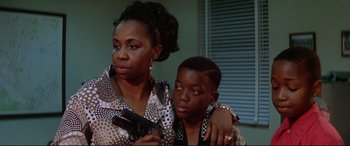 Movie still from “The Getaway” (1972), directed by Sam Peckinpah – A woman and a young boy holding a gun; Close Up shot, Low angle