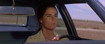 Movie still from “The Getaway” (1972), directed by Sam Peckinpah – A woman sitting in the drivers seat of a car; Close Up shot, Low angle