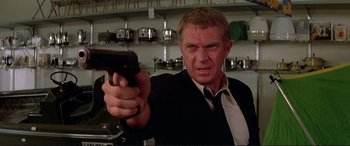 Movie still from “The Getaway” (1972), directed by Sam Peckinpah – A man holding a gun in his hand; Close Up shot, Low angle