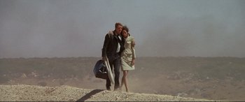 Movie still from “The Getaway” (1972), directed by Sam Peckinpah – A man and a woman are walking in the desert; Wide shot, Low angle
