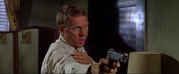Movie still from “The Getaway” (1972), directed by Sam Peckinpah – A person holding a gun; Close Up shot, Low angle