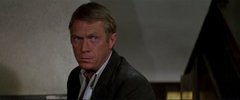 Movie still from “The Getaway” (1972), directed by Sam Peckinpah – A person wearing a suit and tie; Close Up shot, Over the shoulder angle