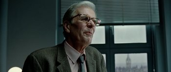 Movie still from “The Ghost Writer” (2010), directed by Roman Polanski – An older man wearing glasses and a suit; Close Up shot, Low angle