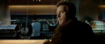 Movie still from “The Ghost Writer” (2010), directed by Roman Polanski – A man sitting in front of a large window; Close Up shot, Over the shoulder angle