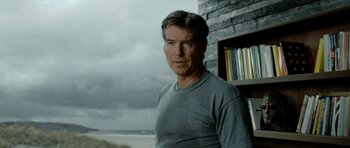 Movie still from “The Ghost Writer” (2010), directed by Roman Polanski – A person wearing a gray t - shirt; Close Up shot, Over the shoulder angle