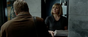 Movie still from “The Ghost Writer” (2010), directed by Roman Polanski – A woman holding a stack of papers in her hands; Close Up shot, Over the shoulder angle