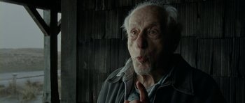 Movie still from “The Ghost Writer” (2010), directed by Roman Polanski – An old man is making a funny face; Close Up shot, Over the shoulder angle