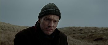 Movie still from “The Ghost Writer” (2010), directed by Roman Polanski – A person wearing a jacket and a hat; Close Up shot, Low angle