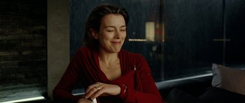 Movie still from “The Ghost Writer” (2010), directed by Roman Polanski – A woman in a red dress is smiling; Close Up shot, Over the shoulder angle