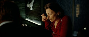Movie still from “The Ghost Writer” (2010), directed by Roman Polanski – A woman sitting at a table with a spoon in her mouth; Close Up shot, Over the shoulder angle