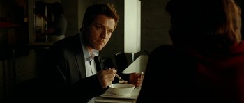 Movie still from “The Ghost Writer” (2010), directed by Roman Polanski – A man sitting at a table with a bowl of food; Close Up shot, Over the shoulder angle
