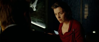 Movie still from “The Ghost Writer” (2010), directed by Roman Polanski – A woman in a red dress is sitting at a table; Close Up shot, Over the shoulder angle