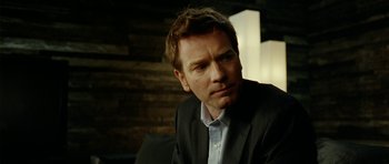 Movie still from “The Ghost Writer” (2010), directed by Roman Polanski – A person wearing a suit and tie; Close Up shot, Over the shoulder angle