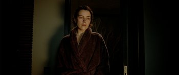 Movie still from “The Ghost Writer” (2010), directed by Roman Polanski – A woman in a brown robe standing in front of a door; Close Up shot, Low angle