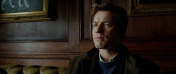 Movie still from “The Ghost Writer” (2010), directed by Roman Polanski – A person sitting in a room; Close Up shot, Low angle