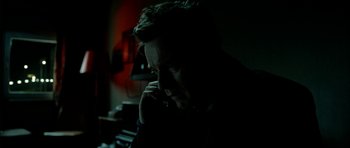 Movie still from “The Ghost Writer” (2010), directed by Roman Polanski – A man sitting in a dark room on a cell phone; Close Up shot, Low angle