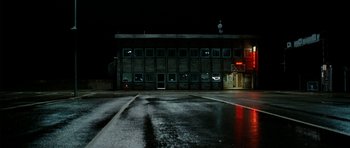 Movie still from “The Ghost Writer” (2010), directed by Roman Polanski – A building that has been boarded up at night; Extreme Wide shot, Low angle