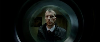 Movie still from “The Ghost Writer” (2010), directed by Roman Polanski – A man in a black jacket and a white shirt; Close Up shot, Low angle