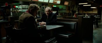 Movie still from “The Ghost Writer” (2010), directed by Roman Polanski – Two men sitting at a table in a restaurant; Medium shot, Over the shoulder angle