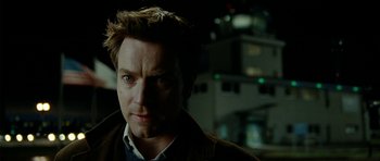 Movie still from “The Ghost Writer” (2010), directed by Roman Polanski – A person wearing a suit and tie; Close Up shot, Over the shoulder angle