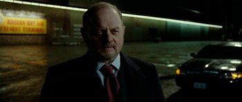 Movie still from “The Ghost Writer” (2010), directed by Roman Polanski – An older man wearing a suit and a tie; Close Up shot, Low angle