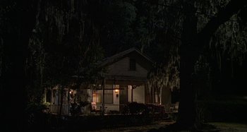 Movie still from “The Gift” (2000), directed by Sam Raimi – A house in the dark at night with a tree; Extreme Wide shot, Low angle