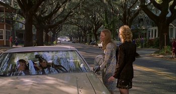 Movie still from “The Gift” (2000), directed by Sam Raimi – Two women standing next to a car on a street; Wide shot, Over the shoulder angle