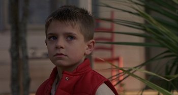 Movie still from “The Gift” (2000), directed by Sam Raimi – A young boy in a red vest looks at the camera; Close Up shot, Low angle