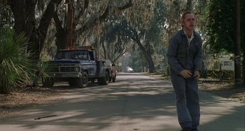 Movie still from “The Gift” (2000), directed by Sam Raimi – A man walking down the street in front of a tow truck; Wide shot, Low angle