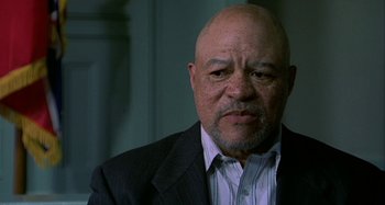 Movie still from “The Gift” (2000), directed by Sam Raimi – An older bald man wearing a suit and tie; Close Up shot, Low angle