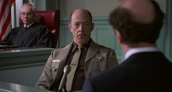 Movie still from “The Gift” (2000), directed by Sam Raimi – A man sitting in front of another man; Medium shot, Over the shoulder angle