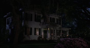 Movie still from “The Gift” (2000), directed by Sam Raimi – A large white house lit up at night; Extreme Wide shot, High angle