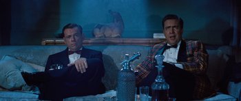 Movie still from “The Girl Can't Help It” (1956), directed by Frank Tashlin – Two men sitting at a table in a restaurant; Medium shot, Low angle